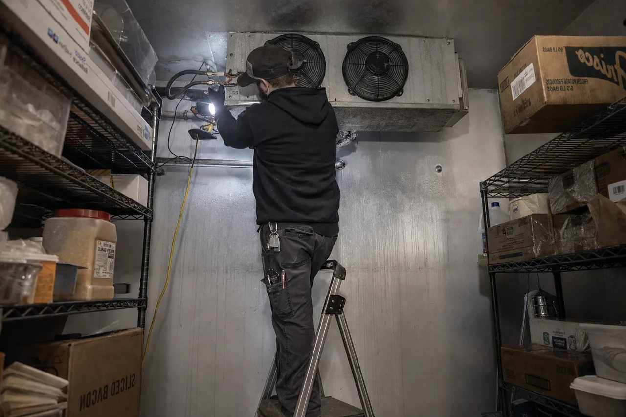 Technician servicing a walk-in cooler in a Bergen County kitchen